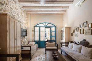 a living room with a couch and a blue door at Villa Aposperitis in Panormos Rethymno