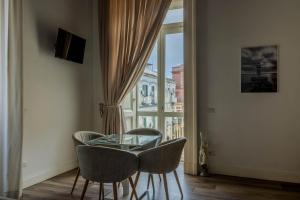 a glass table and chairs in a room with a window at Villa Cua in Ercolano