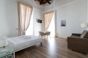 a bedroom with a bed and a couch and a table at Villa Cua in Ercolano