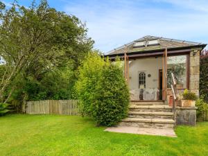a cottage in a garden with stairs and a fence at Wanton Wa's in Edinburgh