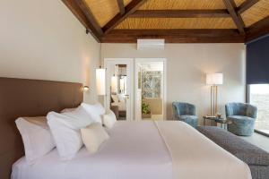 a bedroom with a large bed with white sheets and pillows at Buena Vista in Letojanni