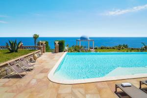 a swimming pool with the ocean in the background at Buena Vista in Letojanni