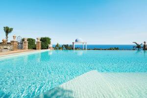a large swimming pool with the ocean in the background at Buena Vista in Letojanni