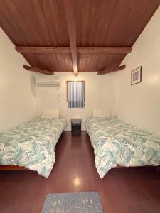 a room with two beds and a window at PavilionSurf&Lodge in Shishikui