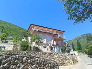 a house on a hill with a stone wall at Apartments Valter Frankovic in Mošćenička Draga