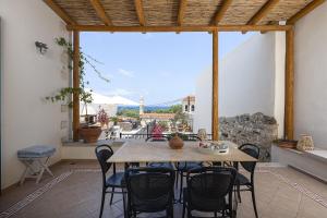 a patio with a table and chairs and a large window at Villa Aposperitis in Panormos Rethymno