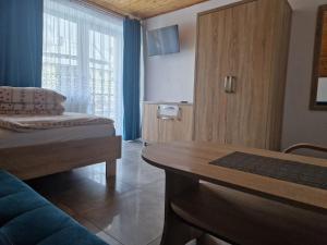 a room with a couch and a table and a screen at Willa OLA in Karpacz
