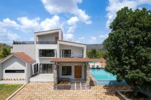 an image of a villa with a swimming pool at Saffronstays Crimson Crest in Khopoli