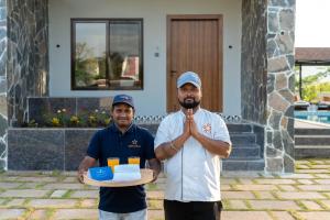 two men standing in front of a house holding a tray of food at Saffronstays Crimson Crest in Khopoli +46 photos