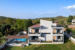 an aerial view of a white house with a yard at Saffronstays Crimson Crest in Khopoli
