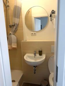 a bathroom with a sink and a mirror at Hotel Wandsbek Hamburg in Hamburg
