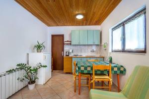 a kitchen with a table and chairs and a refrigerator at Apartment Dragica in Valbandon