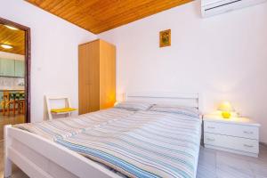 a bedroom with a large bed with a night stand and a table at Apartment Dragica in Valbandon