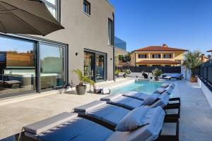 a group of blue lounge chairs next to a swimming pool at Villa Orion - Private Heated Pool, Sauna & Jacuzzi in Rovinj