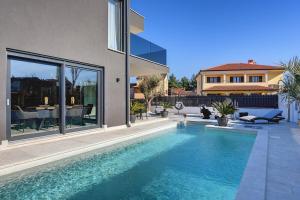 a house with a swimming pool in front of a house at Villa Orion - Private Heated Pool, Sauna & Jacuzzi in Rovinj