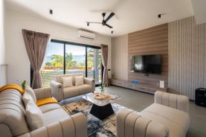 a living room with white furniture and a tv at Saffronstays Crimson Crest in Khopoli