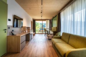 a living room with a couch and a table at NaturHotel Snovik in Kamnik