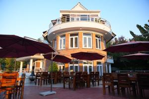 a restaurant with tables and umbrellas in front of a building at Winston's Speakeasy & Inn in Pātan
