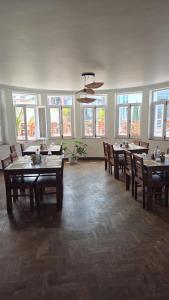 a dining room with tables and chairs and windows at Winston's Speakeasy & Inn in Pātan +10 photos