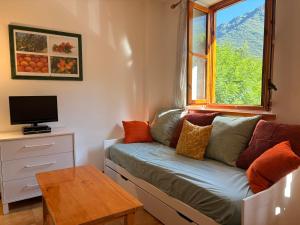 a small living room with a couch and a window at Agradable y rústico, perfecto para parejas - Cuc 7 in Pla de l'Ermita