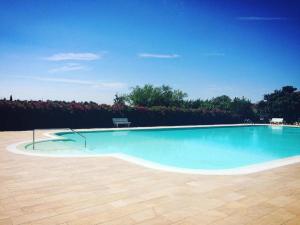 a large swimming pool with a wooden floor at Villa Angiolina in Bardolino