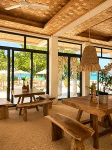 a living room with benches and tables and windows at Samura Panorama Guest House in Thulusdhoo +54 photos