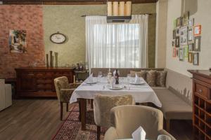 une salle à manger avec une table, des chaises et une horloge dans l'établissement Villa Del Sole, à Dobrevtsi