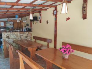 a dining room with a wooden table with flowers on it at Casa David&Alexia 2 Mai in 2 Mai