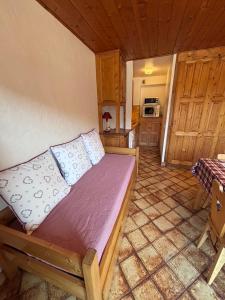 a bedroom with a bed in a room with a kitchen at Studio Crêt du Midi, Chez Francine in Notre-Dame-de-Bellecombe