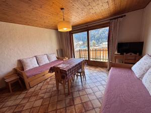 a room with a bed and a table in a room at Studio Crêt du Midi, Chez Francine in Notre-Dame-de-Bellecombe