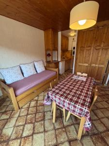 a living room with a couch and a table at Studio Crêt du Midi, Chez Francine in Notre-Dame-de-Bellecombe