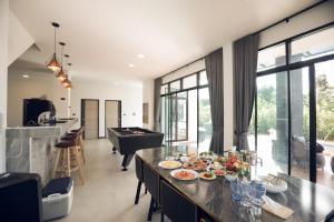 a kitchen and living room with a table with food on it at Issara Private Pool Villa Khaoyai in Pak Chong