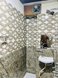 a man taking a picture of a bathroom with a sink at Hari Kamal Invitation in Mathura