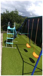 a playground with two swings and a blue chair at Eido da Consaca in Ponteareas +61 photos