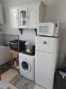 a kitchen with a washing machine and a microwave at Maison d'hôtes du Faubourg Charrault Saint Maixent L'Ecole in Saint-Maixent-lʼÉcole +7 photos