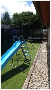 a playground with a blue slide on the grass at Eido da Consaca in Ponteareas