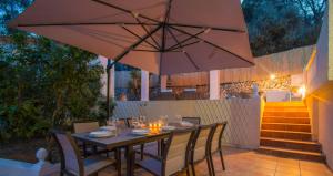 a table with chairs and an umbrella on a patio at Villa SOFIA - Costa Blanca in Benissa
