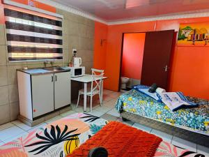a bedroom with a bed and a kitchen with a sink at 48 ON Lindi in Welkom