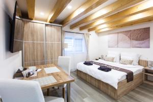 a bedroom with a large bed and a wooden table at Aparthotel Svitavy in Svitavy