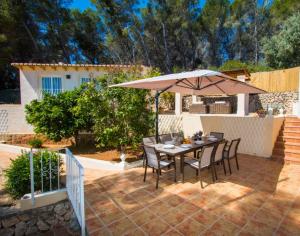 a patio with a table and an umbrella at Villa SOFIA - Costa Blanca in Benissa