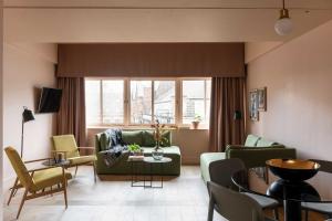 a living room with a green couch and chairs at Whitworth Locke in Manchester