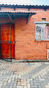 a red brick building with a red door and a window at 48 ON Lindi in Welkom