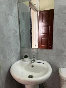 a bathroom with a white sink and a mirror at Noble Park Apartments in Kiserian +17 photos