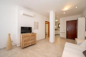 a living room with a television on a wooden cabinet at A 104 Puntavilla in La Maddalena