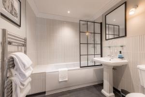 a bathroom with a tub and a sink and a shower at Angel @ KingSt in Knutsford +47 photos