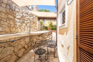 a patio with a table and chairs on a stone wall at A 104 Puntavilla in La Maddalena
