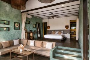 a living room with a couch and a bed at Tanaw Villas in General Luna