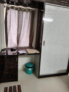 a shower stall with a door in a room at Green fields in Vijayawāda