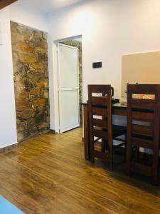 a room with a table and chairs and a stone wall at Kithulgala Cabana Resort in Kitulgala
