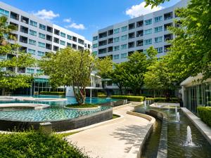 a courtyard with two fountains in front of buildings at Spacious Studio Near BTS Kitchen & Washer in Amphoe Phra Khanong